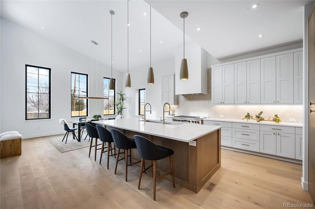 a kitchen with kitchen island granite countertop a sink counter top space and cabinets