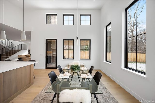 a living room with furniture two window and wooden floor