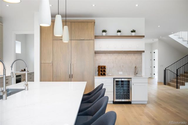 a kitchen with kitchen island a stove and a refrigerator with wooden floor