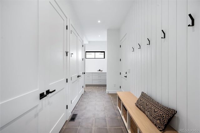 a hallway with white doors wooden floor and windows