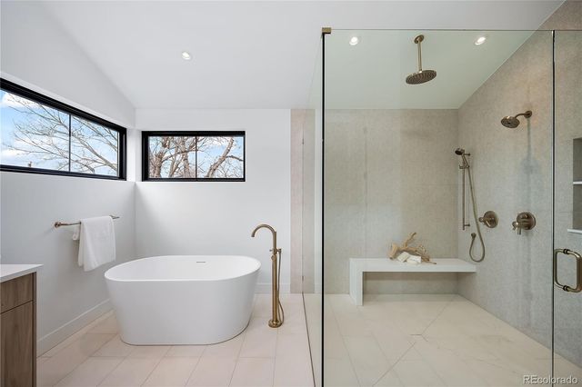 a bathroom with a white tub shower and mirror