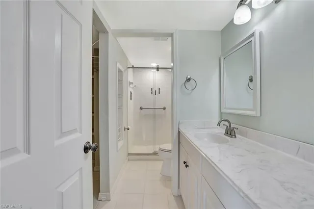 a bathroom with a granite countertop sink two mirror and shower