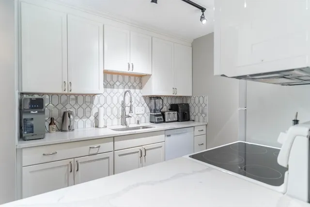 a kitchen with stainless steel appliances granite countertop a sink and a white cabinets
