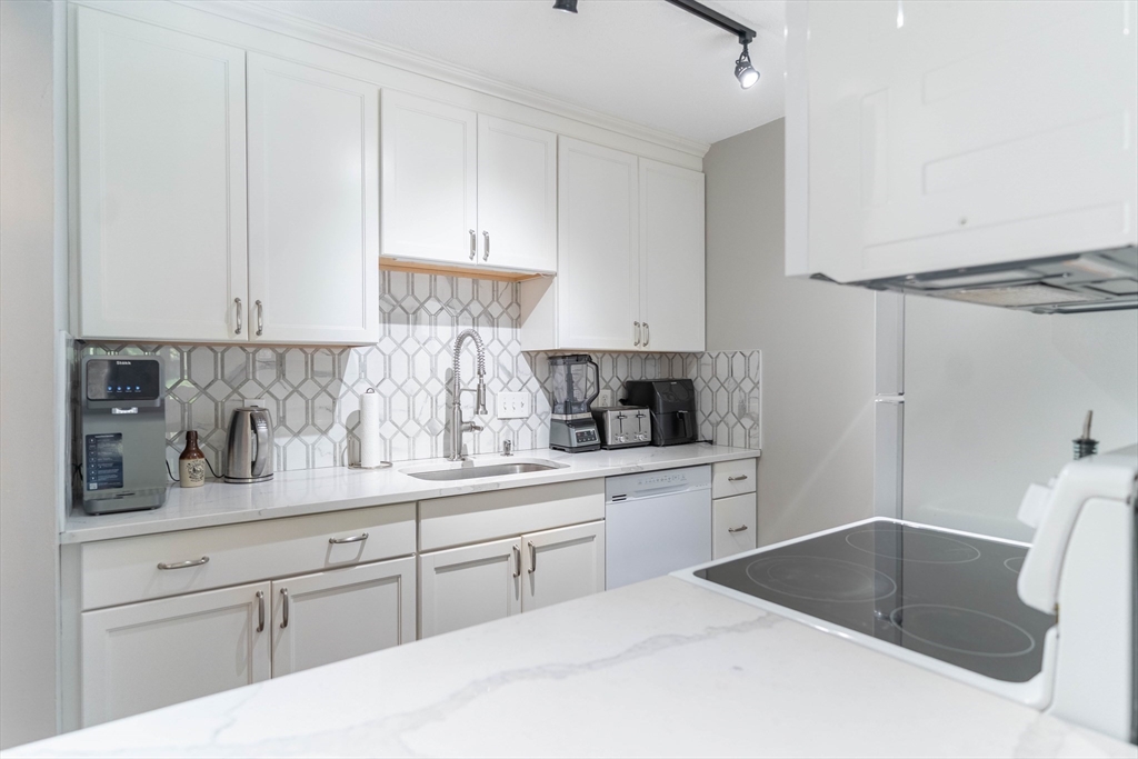 a kitchen with stainless steel appliances granite countertop a sink and a white cabinets