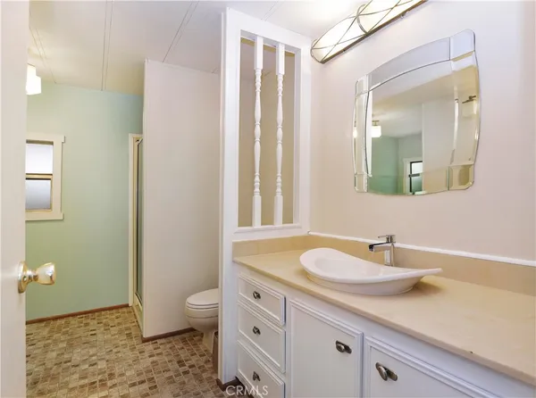 a bathroom with a granite countertop sink a toilet and a mirror