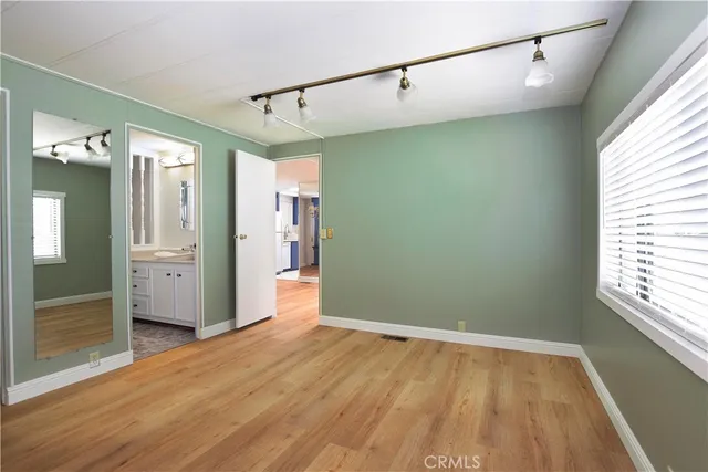 a view of a big room with wooden floor and windows