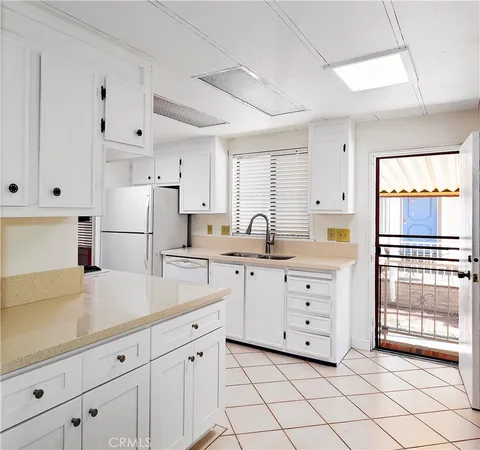 a kitchen with white cabinets and white appliances