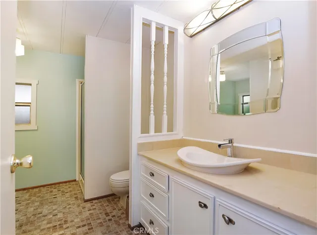 a bathroom with a granite countertop sink a toilet and a mirror