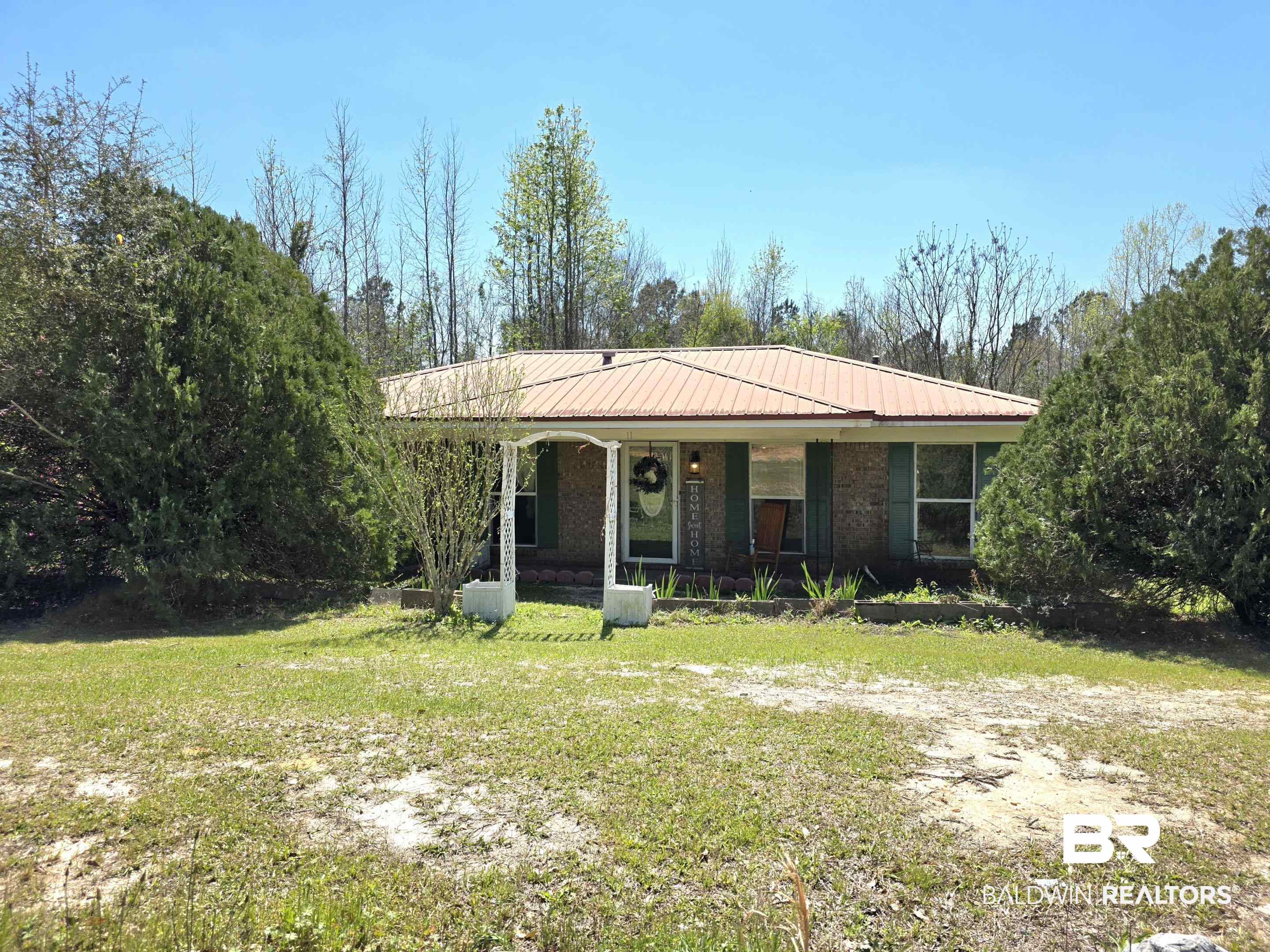 11 Coal Fire Road Jackson, AL 36545 - Photo 2 of 23 View of front of property featuring a porch, a front lawn, and a metal roof