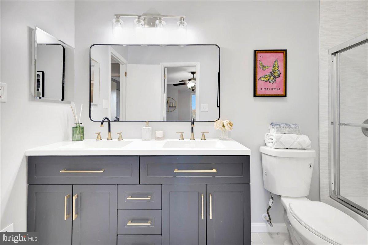 12 Stone Ridge Court Baltimore, MD 21239 - Photo 17 of 38 a bathroom with a toilet a sink a mirror and vanity