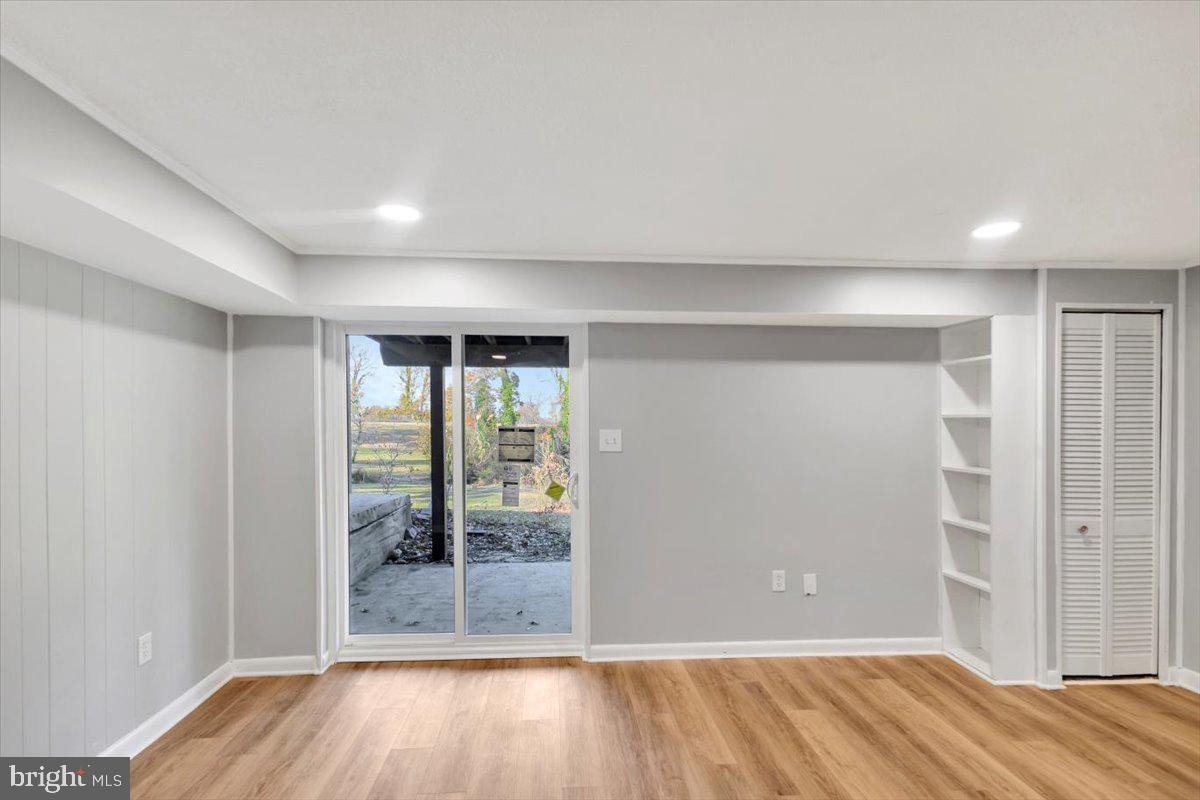 12 Stone Ridge Court Baltimore, MD 21239 - Photo 24 of 38 an empty room with wooden floor and door