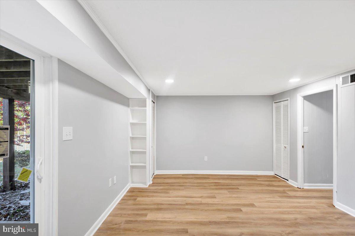 12 Stone Ridge Court Baltimore, MD 21239 - Photo 25 of 38 a view of an empty room with wooden floor and a window