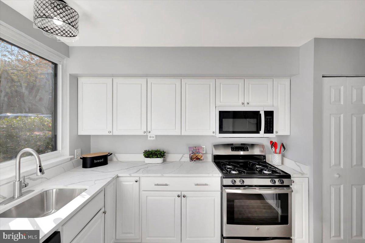 12 Stone Ridge Court Baltimore, MD 21239 - Photo 7 of 38 a kitchen with stainless steel appliances a stove a sink a microwave and cabinets