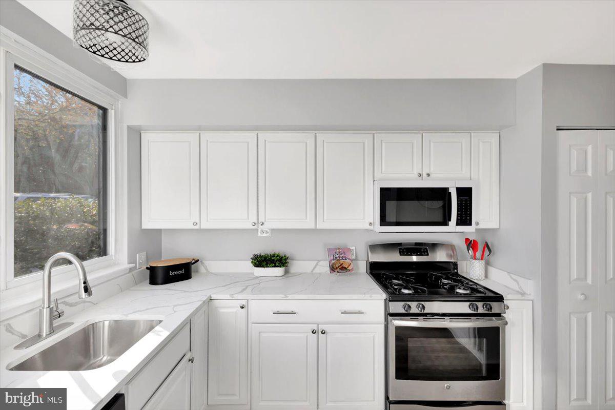 12 Stone Ridge Court Baltimore, MD 21239 - Photo 8 of 38 a kitchen with stainless steel appliances a stove a sink a microwave and cabinets