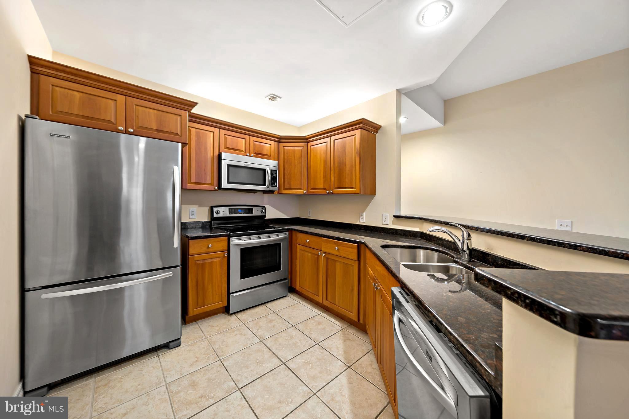 1600 Arch Street, Unit 1116 Philadelphia, PA 19103 - Photo 2 of 23 a kitchen with granite countertop a refrigerator and a stove top oven
