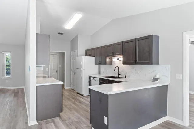 a kitchen with stainless steel appliances a refrigerator a sink a stove a microwave and island