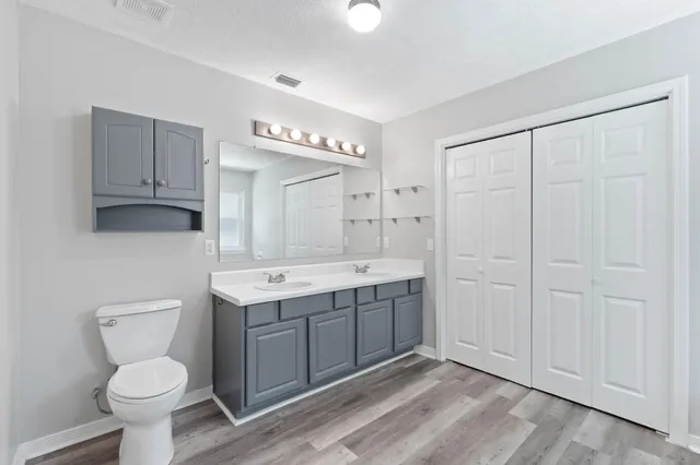 a spacious bathroom with a toilet sink and mirror