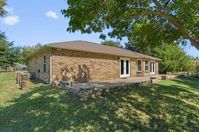 a backyard of a house with table and chairs