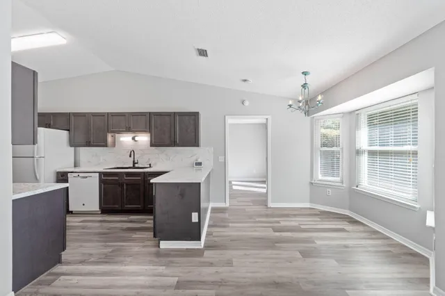 a kitchen with stainless steel appliances kitchen island granite countertop a stove and a sink