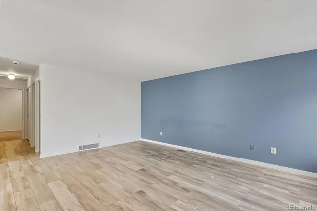a view of an empty room and wooden floor