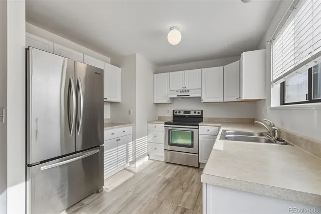 a kitchen with a refrigerator stove and sink