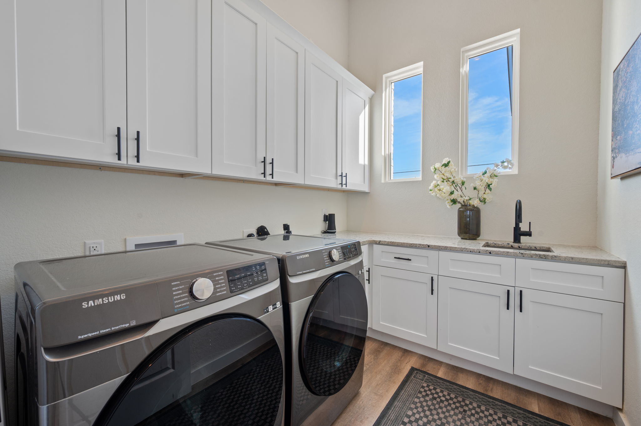 8604 Bar K Ranch Road Lago Vista, TX 78645 - Photo 14 of 37 Laundry room with washing machine and dryer, light wood-style floors, and cabinet space