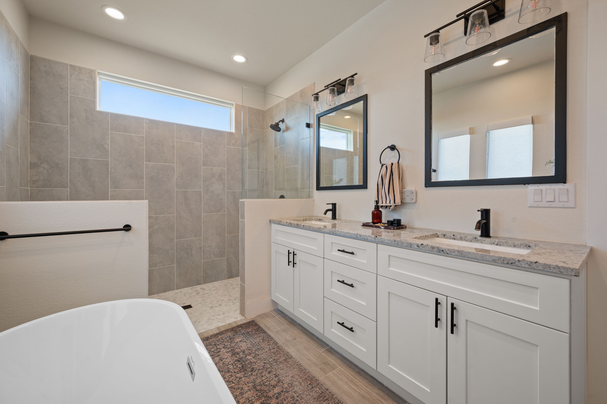 8604 Bar K Ranch Road Lago Vista, TX 78645 - Photo 17 of 37 Bathroom featuring double vanity, a freestanding tub, a walk in shower, and recessed lighting