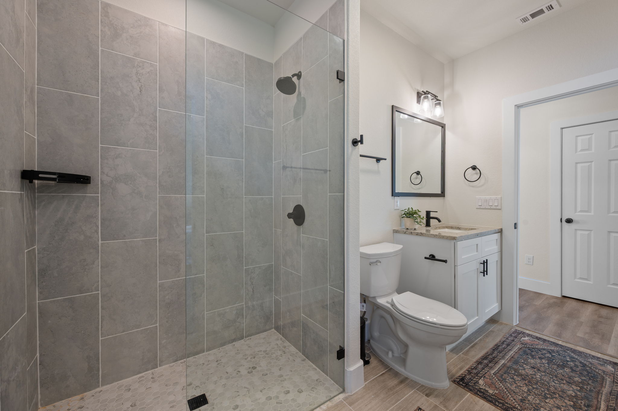 8604 Bar K Ranch Road Lago Vista, TX 78645 - Photo 26 of 37 Full bathroom with wood finish floors, a walk in shower, and vanity