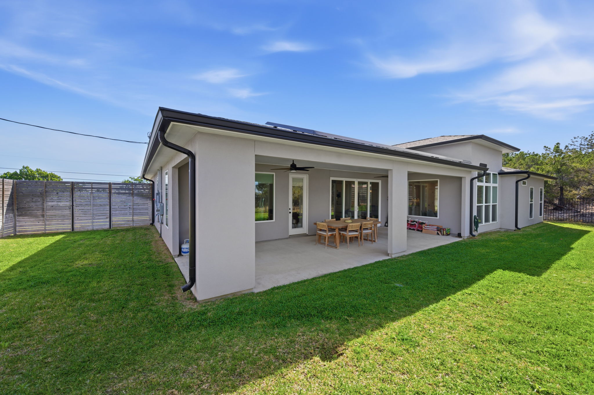 8604 Bar K Ranch Road Lago Vista, TX 78645 - Photo 31 of 37 Rear view of property featuring a fenced backyard, stucco siding, ceiling fan, and a patio