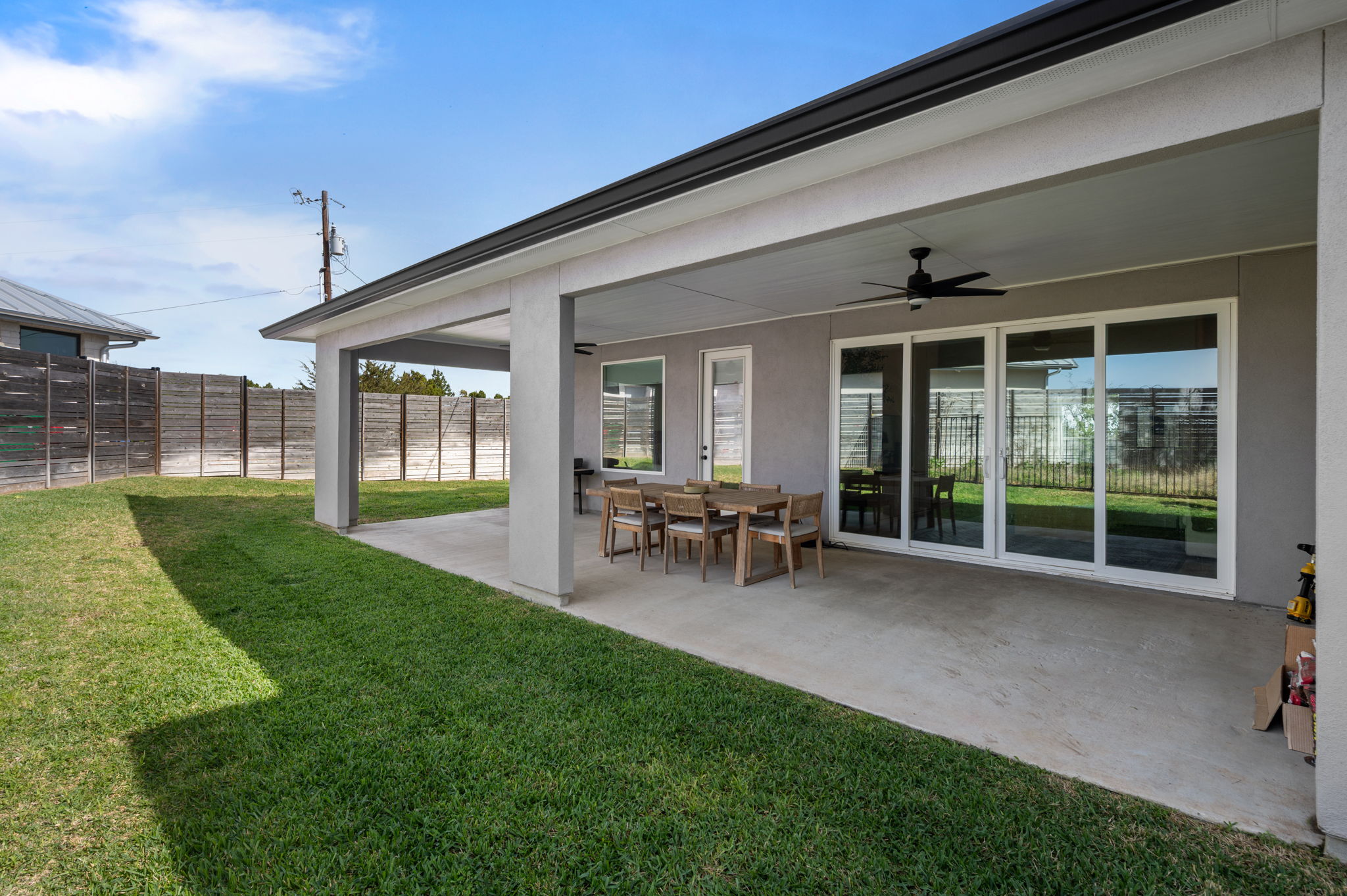 8604 Bar K Ranch Road Lago Vista, TX 78645 - Photo 34 of 37 Fenced backyard featuring ceiling fan, a patio, and outdoor dining space
