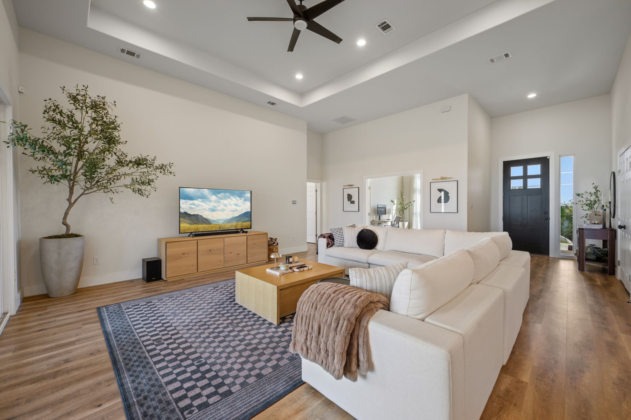8604 Bar K Ranch Road Lago Vista, TX 78645 - Photo 4 of 37 Living area with ceiling fan, a tray ceiling, wood finished floors, and recessed lighting