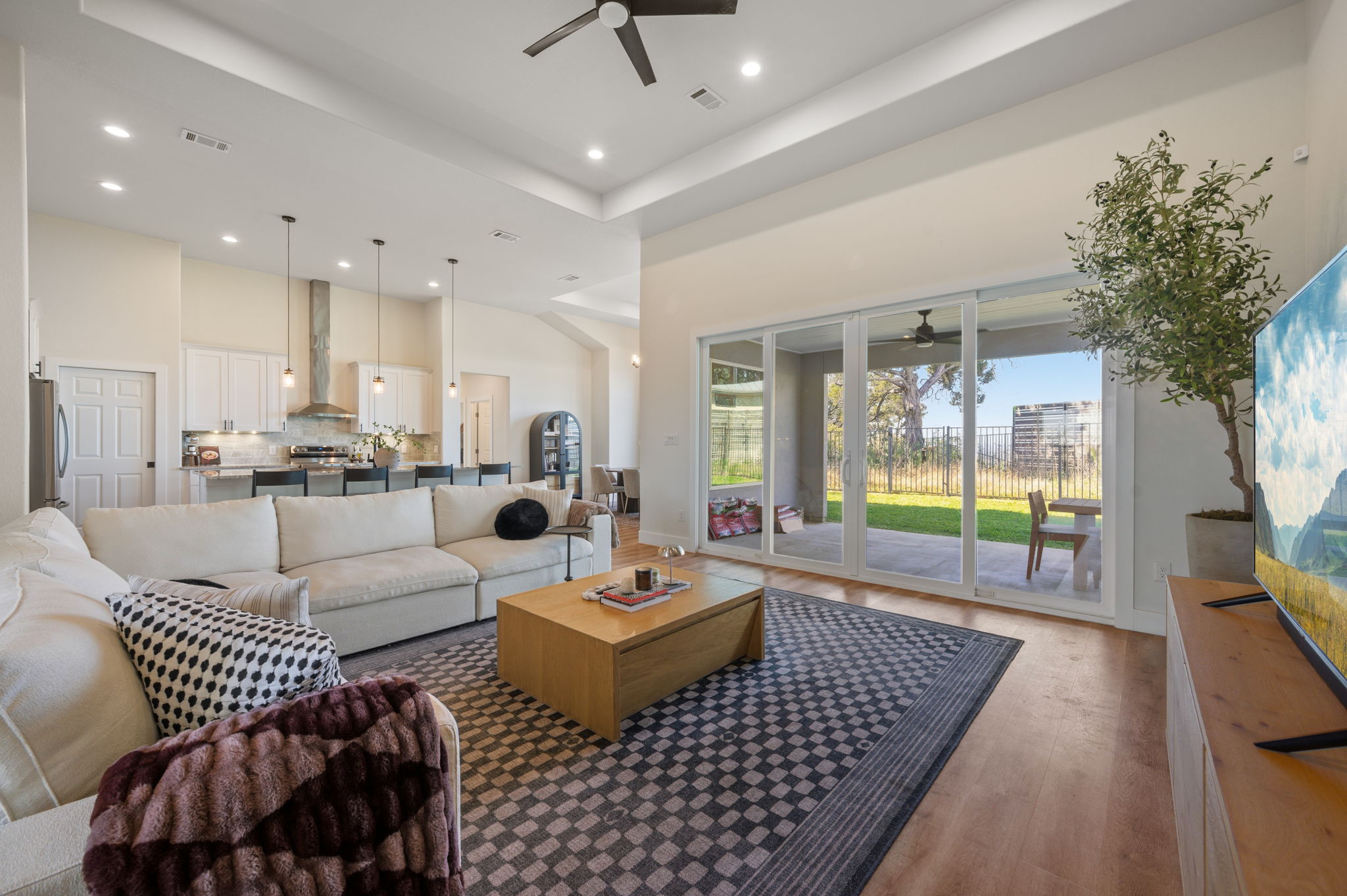 8604 Bar K Ranch Road Lago Vista, TX 78645 - Photo 5 of 37 Living area featuring ceiling fan, a raised ceiling, wood finished floors, and recessed lighting