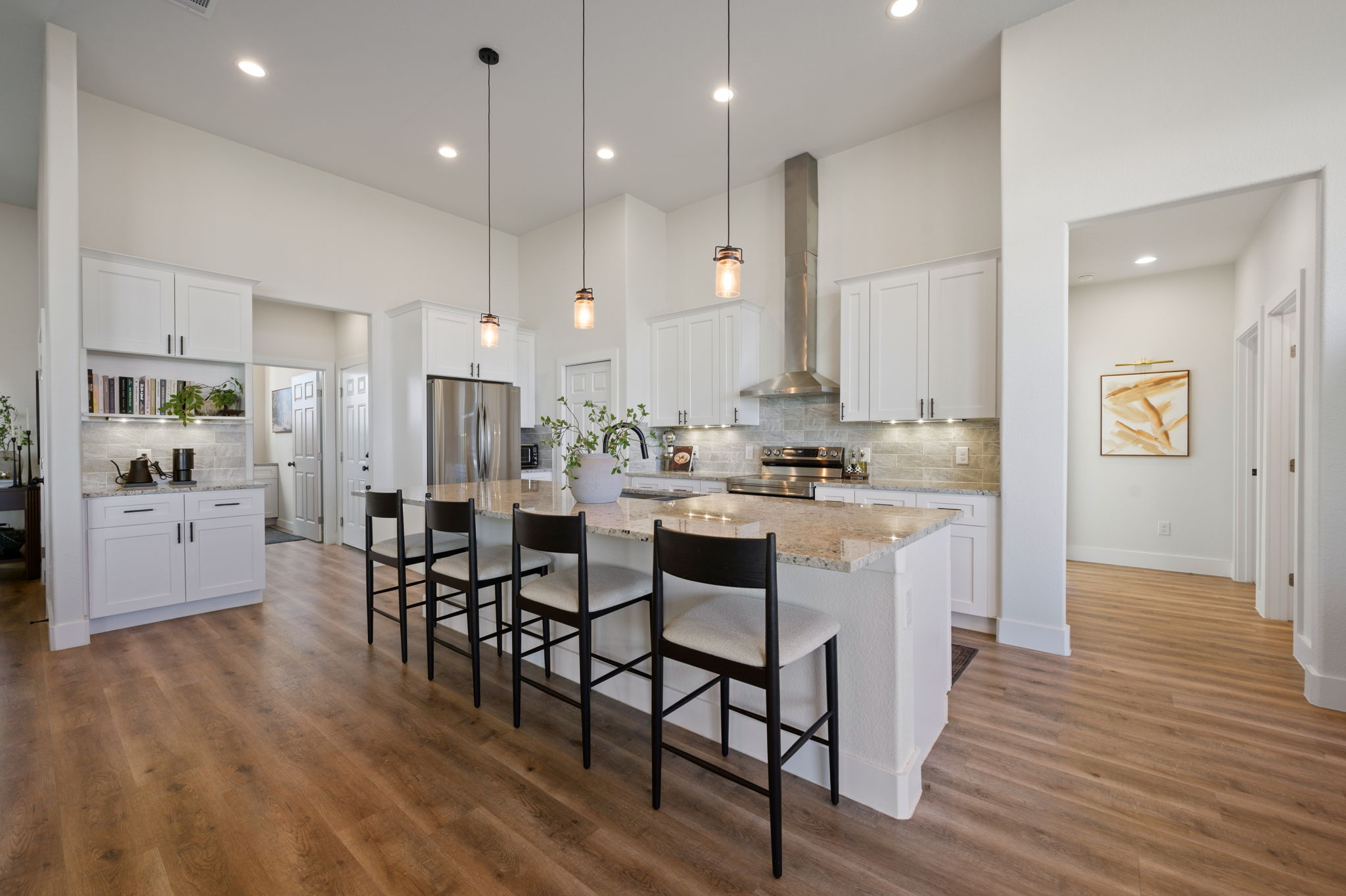 8604 Bar K Ranch Road Lago Vista, TX 78645 - Photo 8 of 37 Kitchen featuring backsplash, white cabinets, a breakfast bar, and a high ceiling