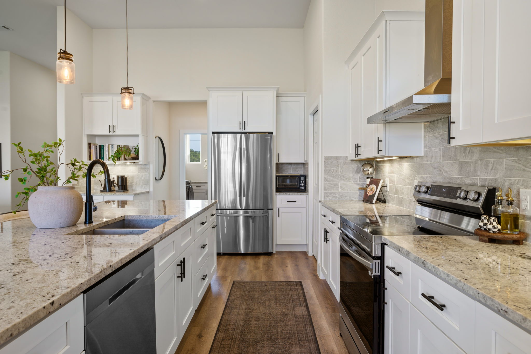 8604 Bar K Ranch Road Lago Vista, TX 78645 - Photo 10 of 37 Kitchen with stainless steel appliances, white cabinets, dark wood-style floors, and light stone counters
