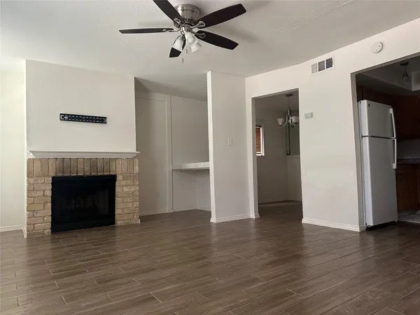 a view of a livingroom with a fireplace and a ceiling fan