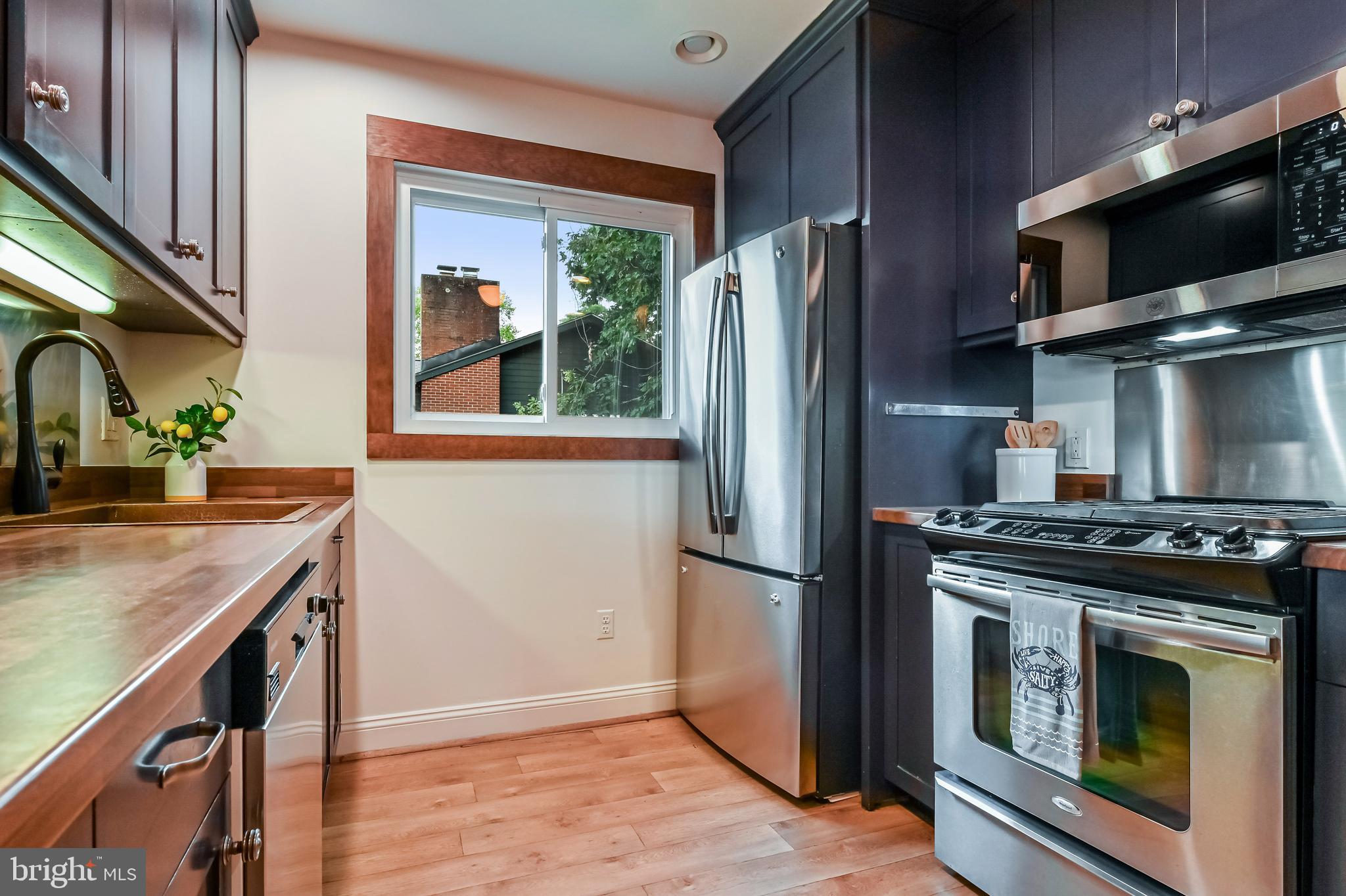 769 Robin Hood Road Annapolis, MD 21405 - Photo 31 of 79 a kitchen with stainless steel appliances granite countertop a stove a refrigerator and a sink with wooden floor