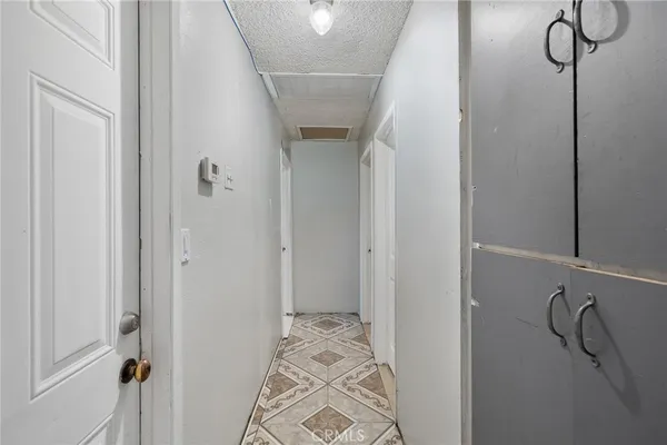 a bedroom with a bed a dresser and potted plant