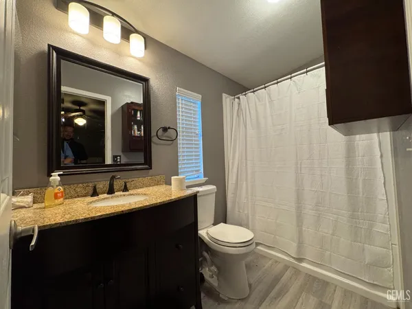a bathroom with a double vanity sink toilet and a mirror