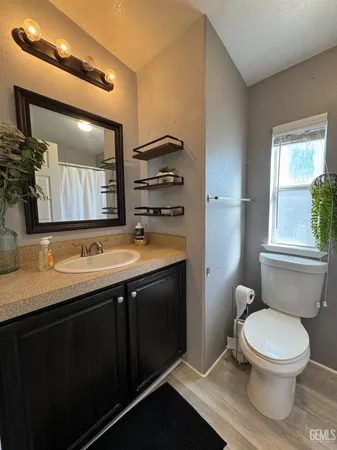 a bathroom with a toilet sink double vanity and mirror