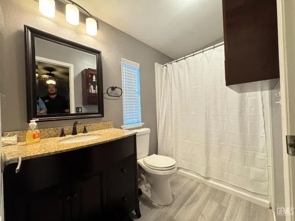 a bathroom with a double vanity sink toilet and a mirror