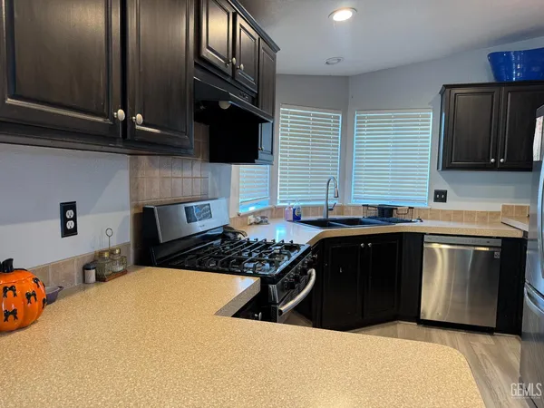 a kitchen with a sink a stove and cabinets
