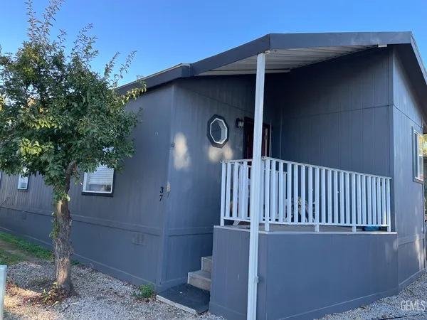 a side view of a house with a tree
