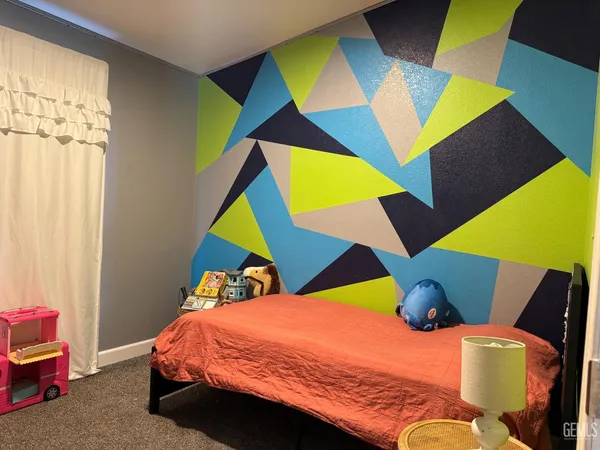 a bedroom with a bed and a painting on the wall
