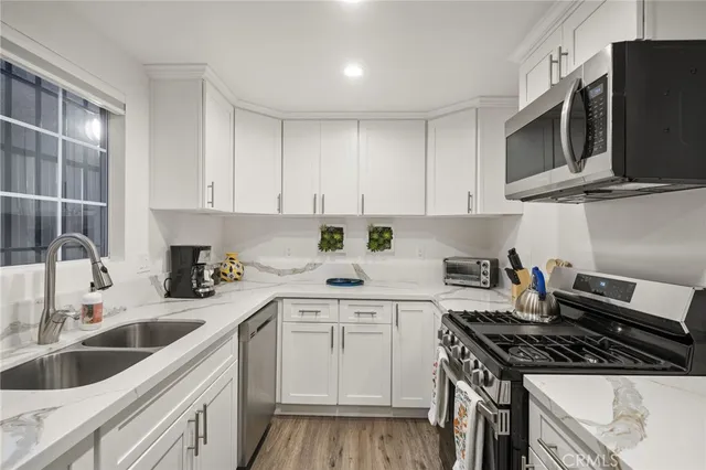 a kitchen with stainless steel appliances granite countertop a sink stove and microwave