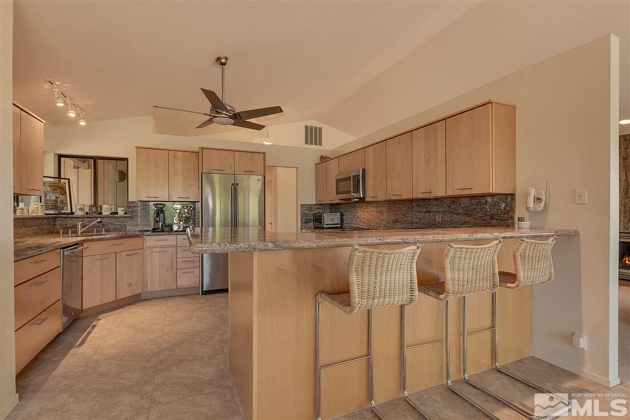 12935 Roseview Lane Reno, NV 89511 - Photo 6 of 17 a kitchen with stainless steel appliances granite countertop a stove a refrigerator and white cabinets with wooden floor