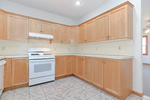 a kitchen with white cabinets and white appliances
