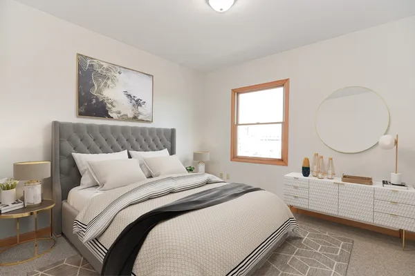 a bedroom with a bed mirror and window