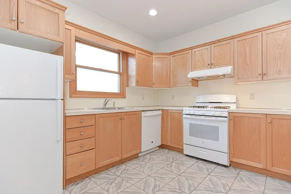 a kitchen with granite countertop white cabinets and white appliances