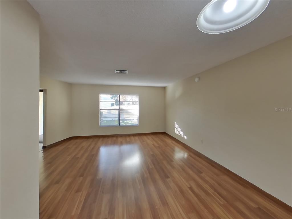 Undisclosed Address Spring Hill, FL 34608 - Photo 2 of 16 an empty room with wooden floor and windows