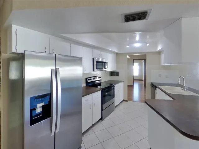 a large kitchen with cabinets and stainless steel appliances